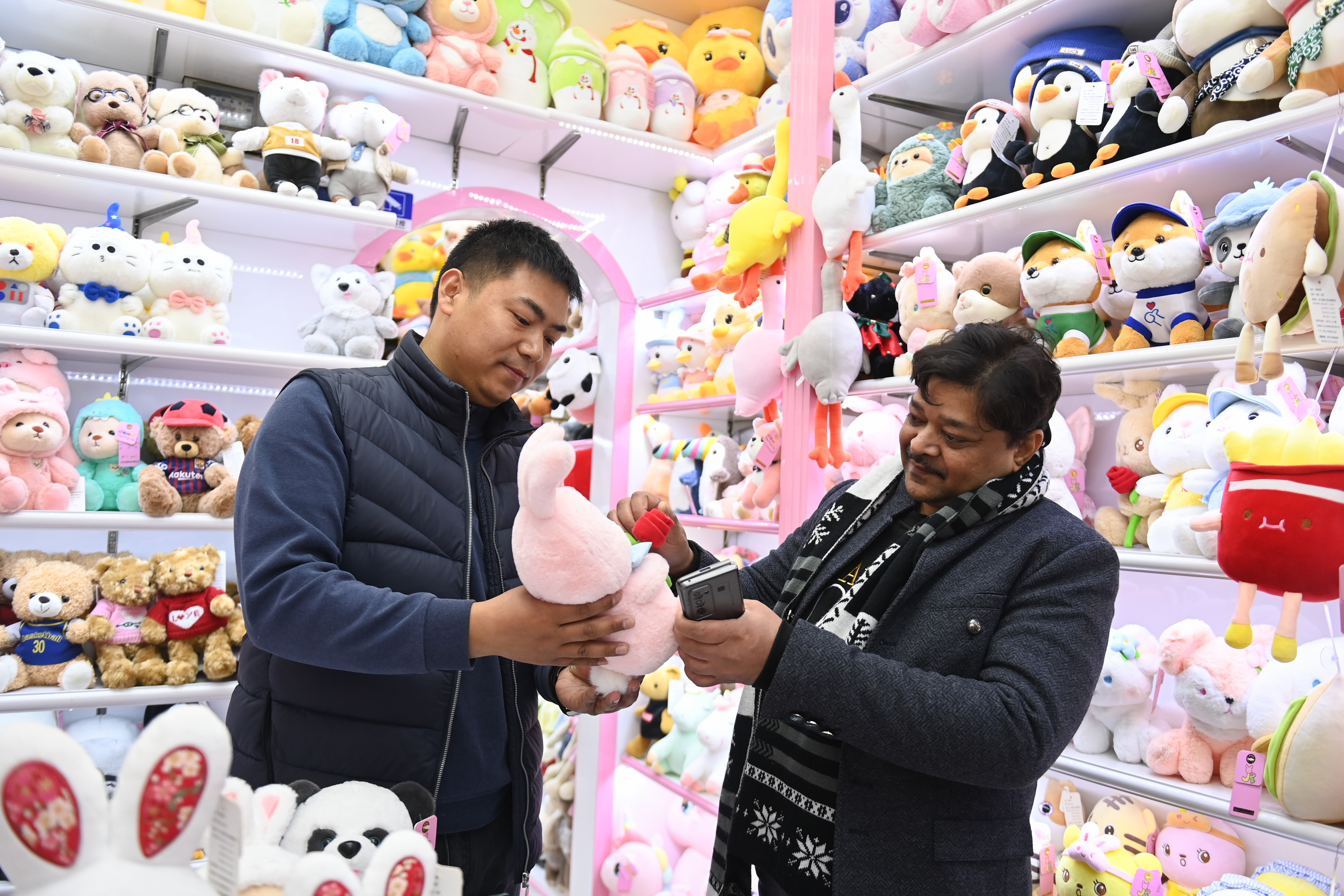2023年2月2日，來(lái)自印度的客商（右）在義烏國際商貿城的一家玩具店鋪內選購。